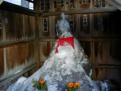 山盛りの塩と顔が崩れた地蔵さん