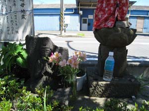 地蔵と説明板の間に欠けた観音の石像