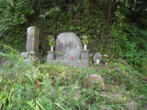 草むらの中に3つの石像、向って右の小さな石像がいんぼ地蔵