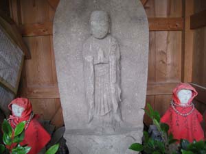 左右に赤いべべを着た小さな地蔵さん